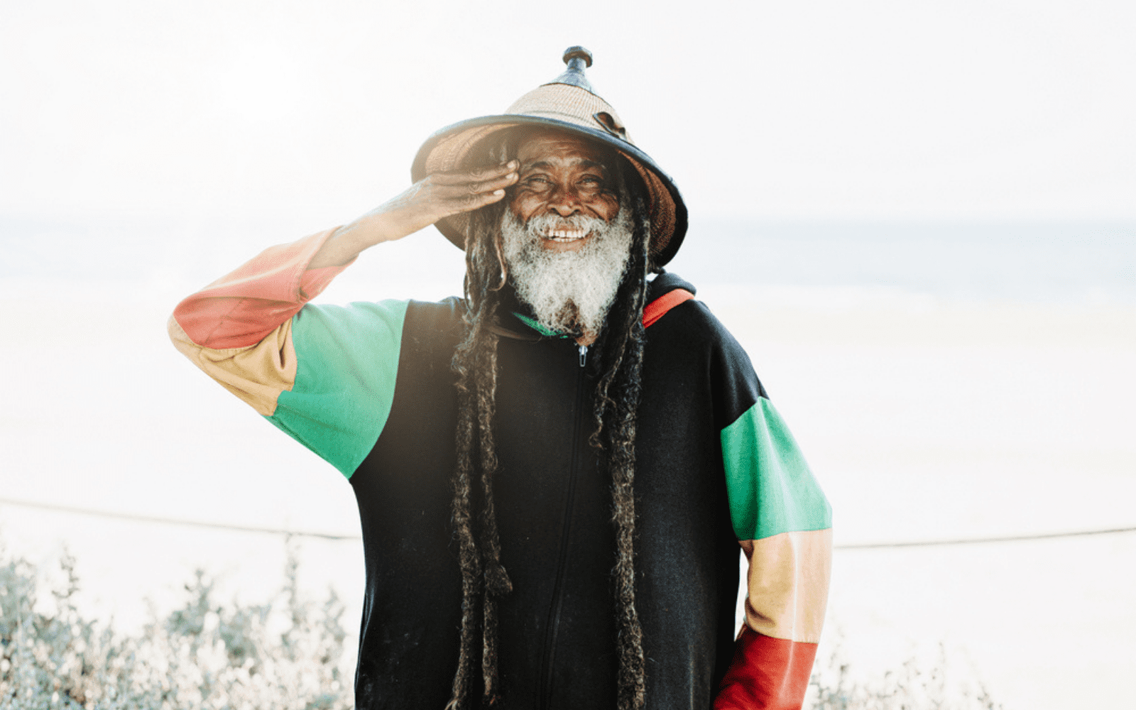Photo d'un vieux rastafari portant de longue dreadlocks et des habits vert jaune rouge