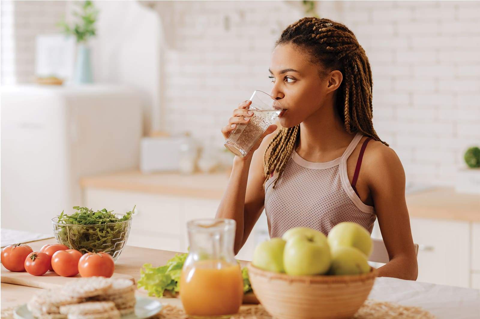 Femme noire avec dreadlocks, sportive, prenant son petit dejeuner. Fruits et legumes.