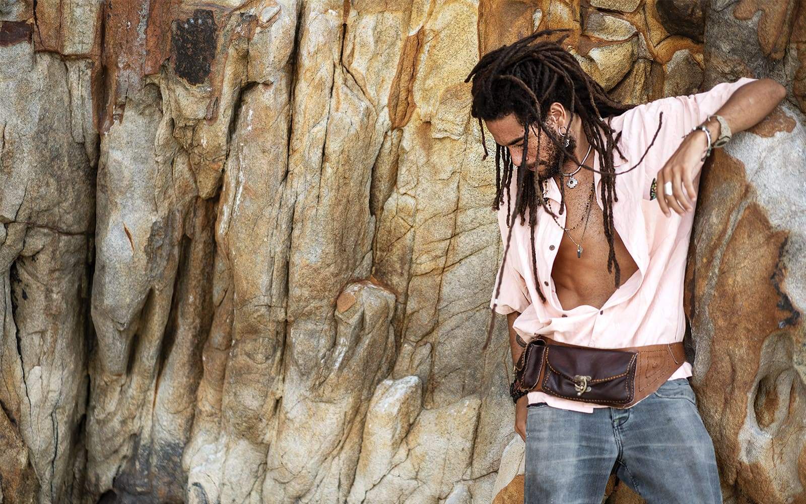 Homme-en-chemise-avec-dreadlocks-devant-rochers
