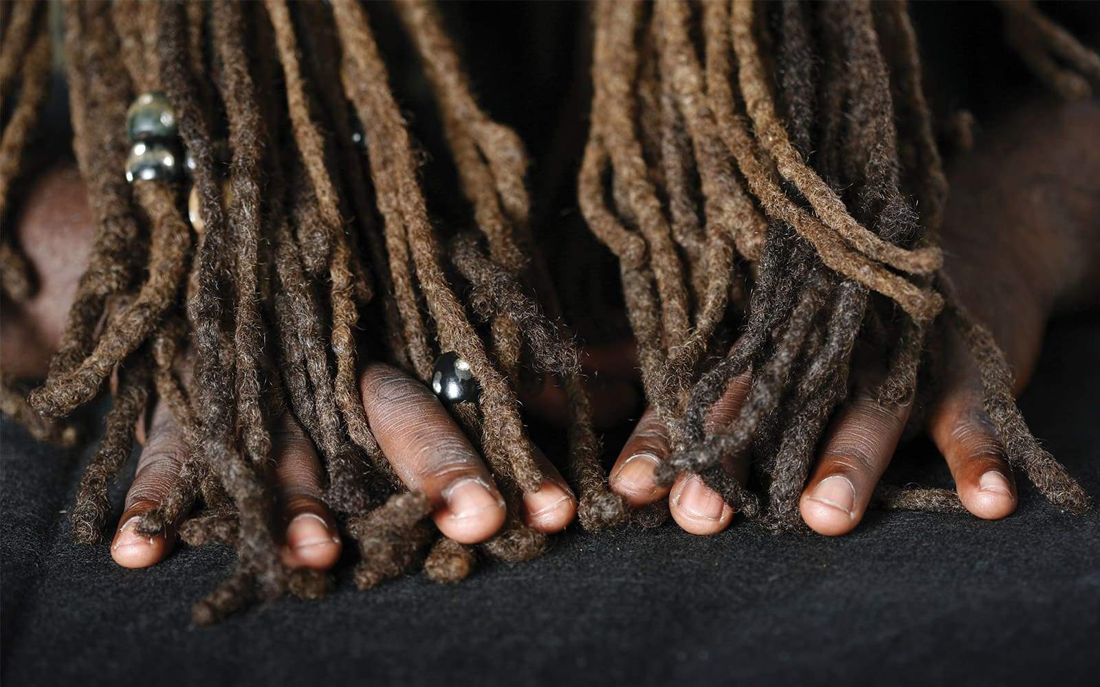Homme mettant ses doigts au travers de ses dreadlocks
