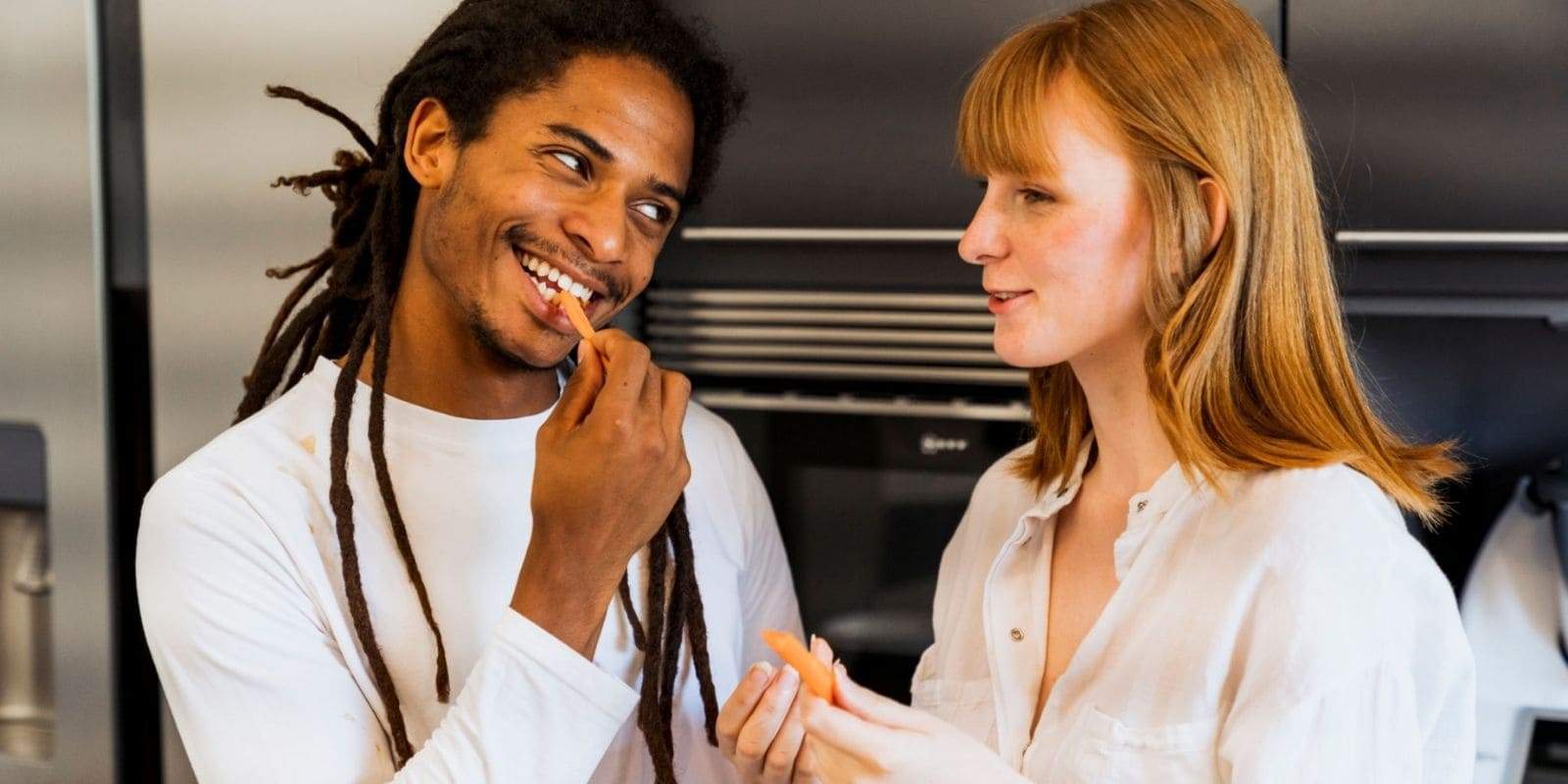 Un rastaman et sa copine mangeant des carottes, complices