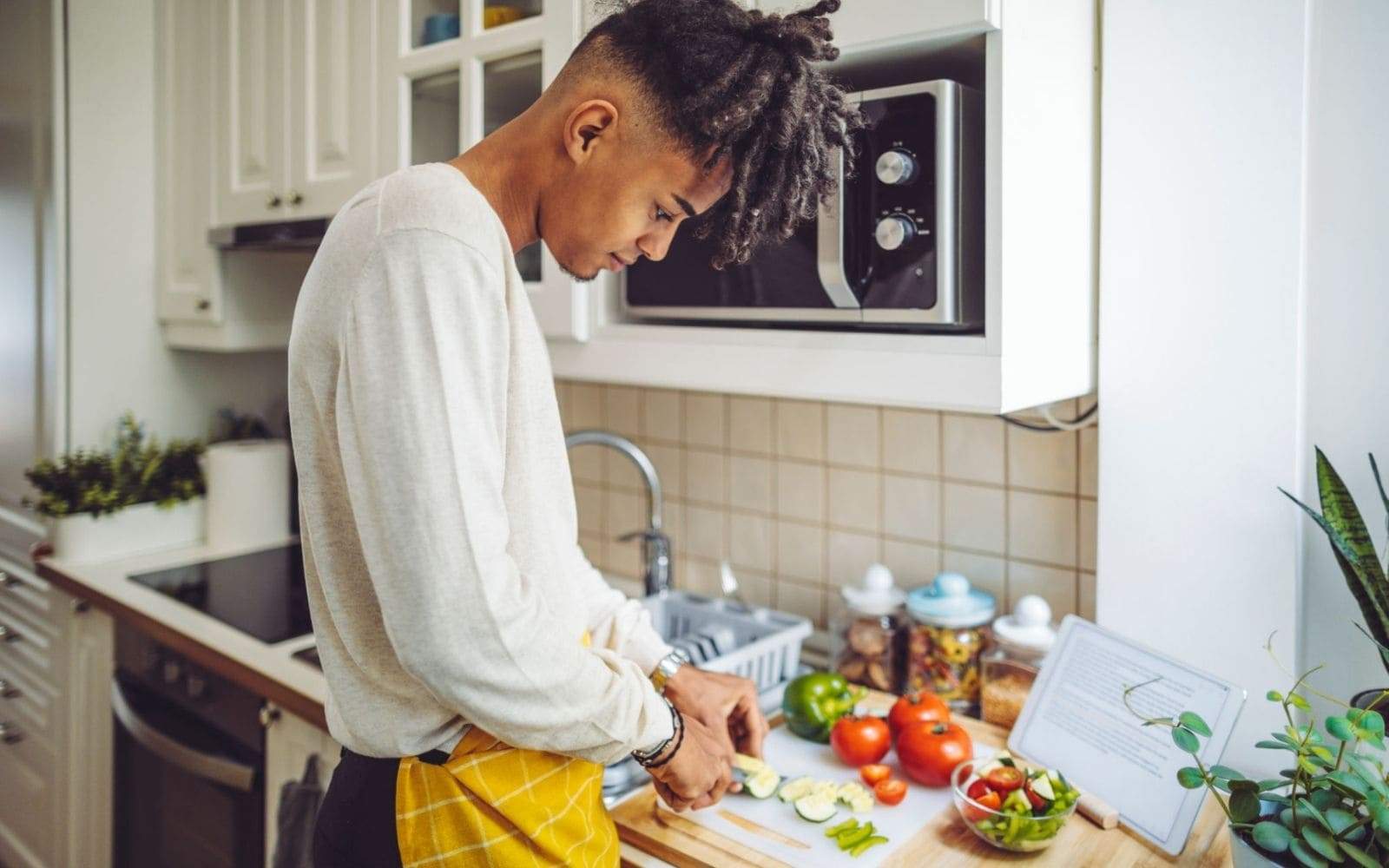 Jeune rasta cuisinant des légumes