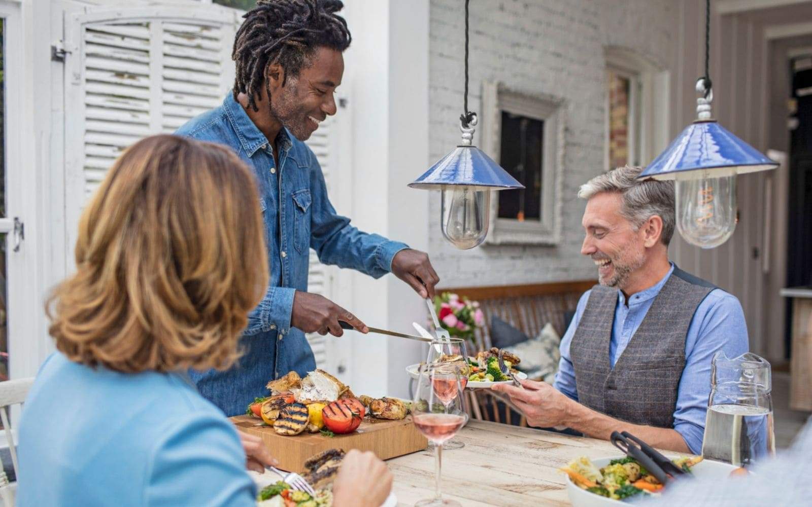 Homme avec dreadlocks servant a manger a des amis