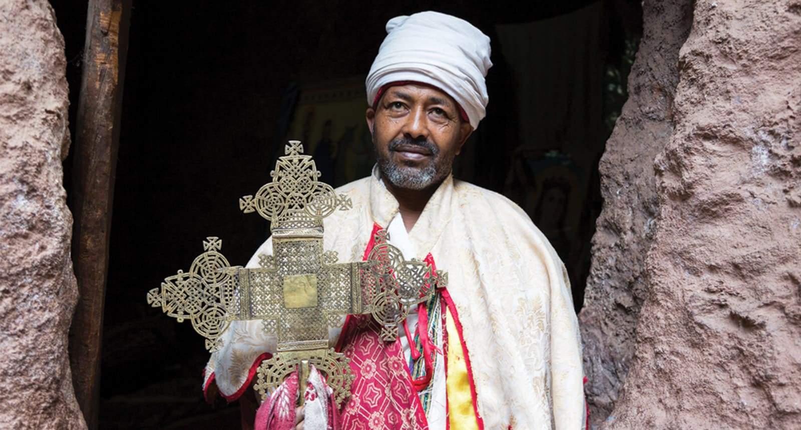 Un homme serrant une croix d'éthiopie dans les mains